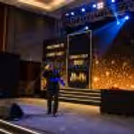 Family day celebration with a corporate magician performing live magic on stage with an LED screen and event lights