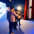 A magician performing a corporate magic show live with audience participation and stage illusions.
