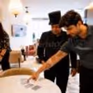 At a party entertaining show, a professional magician performs an interactive card magic trick with a guest.