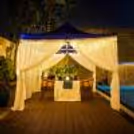 Romantic cabana poolside candlelight dinner setup at Grand Mercure Bangalore with candles and floral décor.