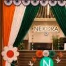 Patriotic hanging decorations, flower sunboards and satin drapes are some of the elegant Independence Day Tricolor Entrance Decoration options for office events.