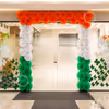 Orange, white, and green paper rosettes entrance wall decor for Independence Day entrance decoration.