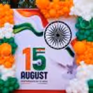 Close-up of the backdrop for the Independence Day celebration in the office with Ashoka Chakra, tricolour wave and balloon clusters.