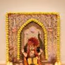 A traditional Ganesh Chaturthi backdrop with Peacock Artwork and Lotus Motifs and Ornate Central Arch.