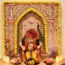 Traditional Ganesh Chaturthi backdrop decoration with Pink Pearl Tassels, hanging Flower details, and decorative lighting.