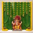 DIY Banana Leaf Ganpati Backdrop comes with vertical yellow flower strings and traditional bell hangings.