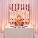 Golden Stand with Elegant Ganpati Backdrop, Lotus Flowers and Decorative Hanging Lights.