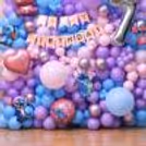 A Stitch birthday balloon wall in view with balloons in pastel shades, foil characters, and party accents.
