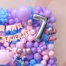 Close-up of colorful Stitch birthday decoration with chrome pink balloons, character cutouts and a big age balloon.