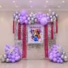 Pink foil fringe curtains and Huntrix character cutouts complete the K-pop party display.