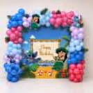 Birthday Balloon Wall with colourful blue, pink and purple balloon arch and tropical character backdrop.