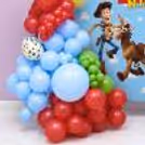 Close-up of Toy Story birthday decoration with colourful latex balloons, character artwork and themed backdrop.