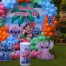 Close-up of a customised Stitch birthday wall with tropical palm leaves and cutouts of the character.