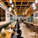 Modern hotel restaurant with elegant seating, wooden interiors, ambient pendant lighting, and beautifully arranged dining tables.