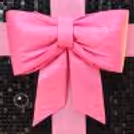 Black background with a large pink satin bow for a Blackpink-inspired birthday photo booth.