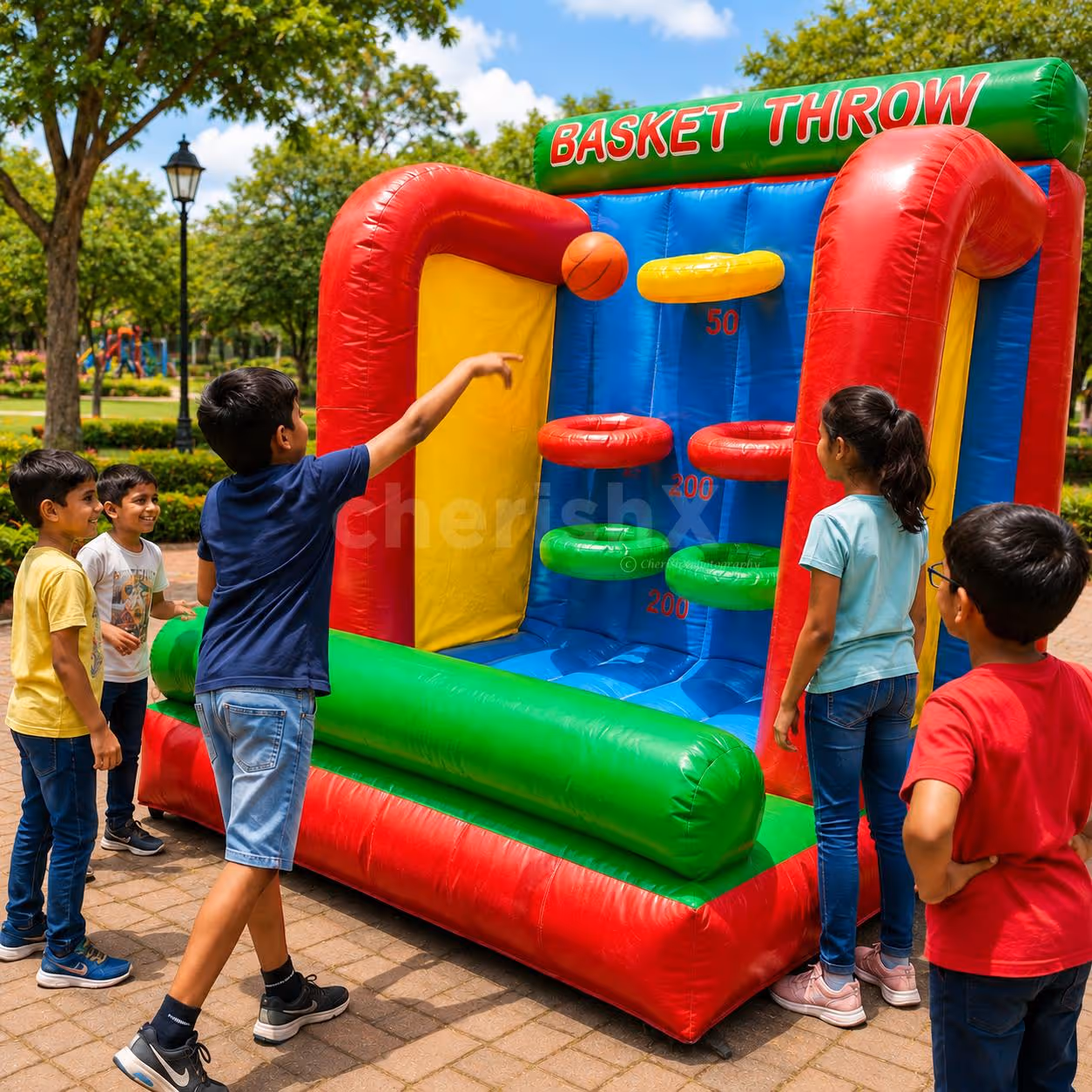 Children shooting baskets on a large inflatable basketball during an outdoor activity.