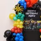 Roblox Birthday Balloon Setup with bunches of red, yellow, blue, green and black balloons around a gaming background.