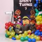 Themed characters, floating balloons, balloon garland and a custom birthday backdrop with a Roblox Adventure theme.