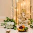 Golden circular frame with design of bells and white jasmine garland for Ganesh Chaturthi.