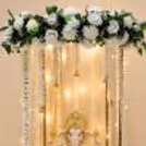 Ganesh idol against a soft pink curtain backdrop with elegant floral decoration.
