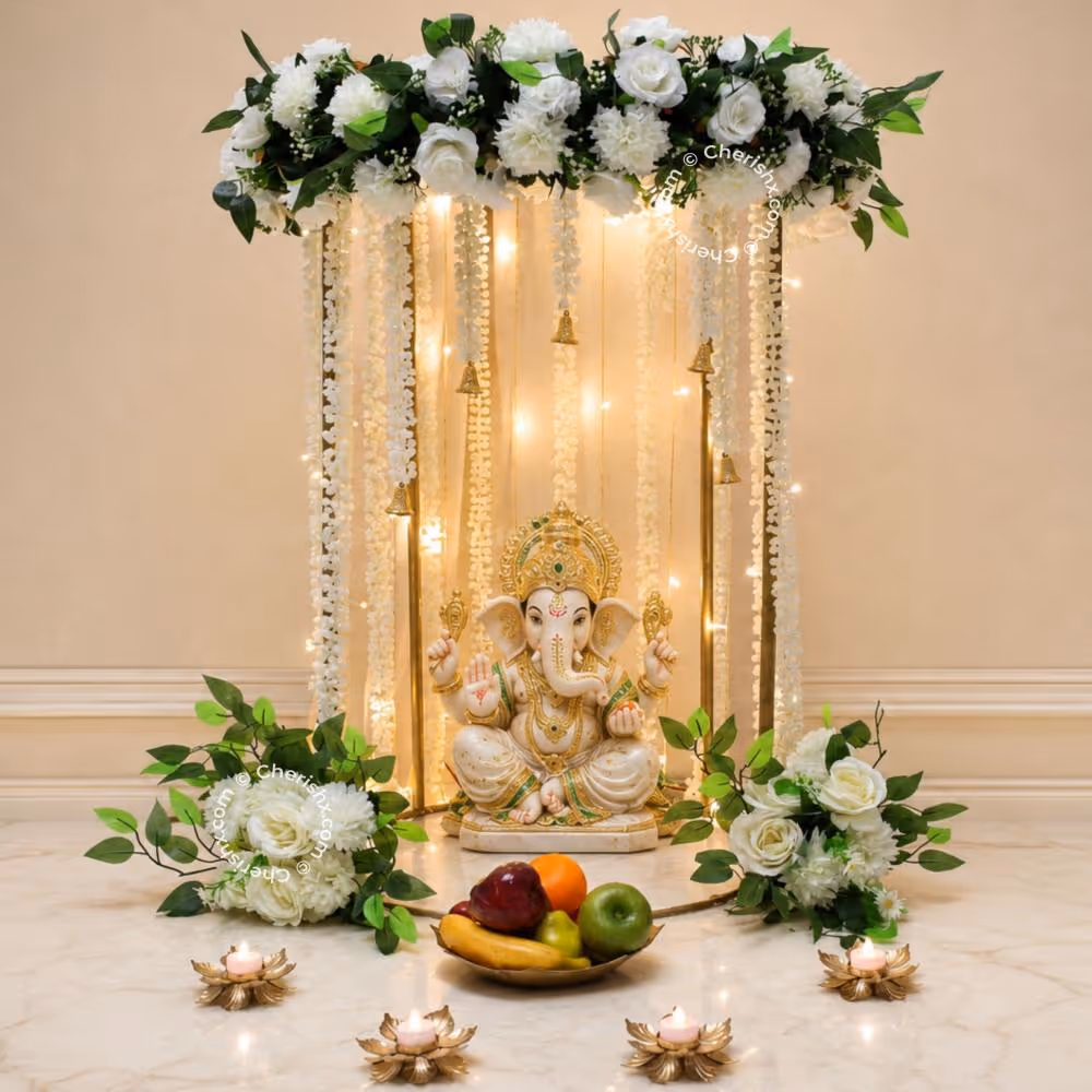 Close-up of a top flower arrangement with white flowers, green leaves and a hanging golden bell.