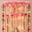 Ganesh Chaturthi decoration with pink rose bell strings and a gold frame with hanging beautiful ornaments.Ganesh Chaturthi decoration with pink rose bell strings and a gold frame with hanging beautiful ornaments.