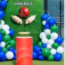 Personalised Cricket Birthday Table Background with a red cricket ball, bats, and a themed Table with a red round.