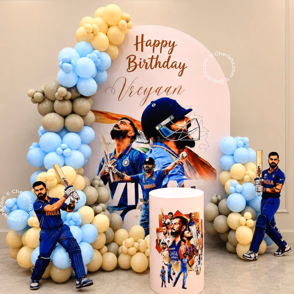 The King’s Cricket Celebration decor features a personalised birthday backdrop with a pastel blue and beige balloon arch.