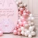 Welcome setup with baby pram cutout surrounded by pastel pink and white balloons.