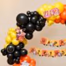 Vibrant yellow, orange & black balloon arch