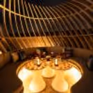 Romantic private gazebo dining setup with warm candlelight, rose petals, elegant tables and a luxurious rooftop ambience.