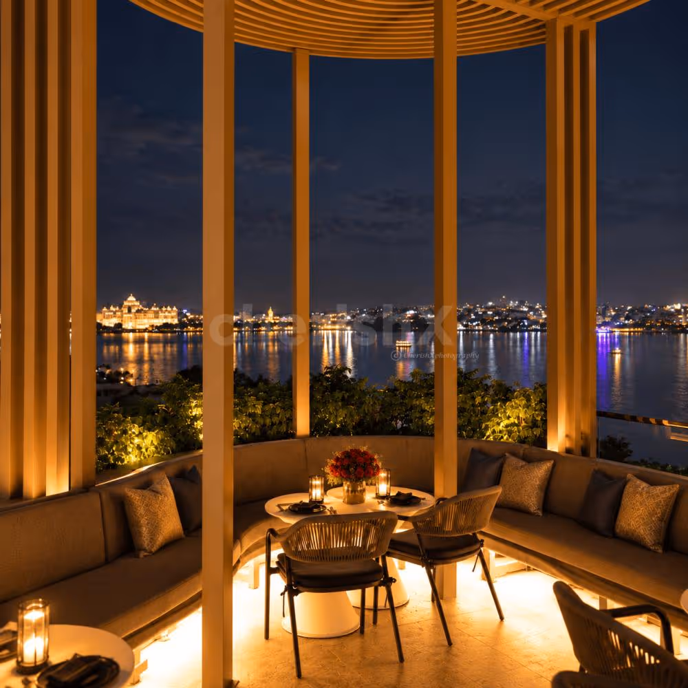Romantic rooftop dinner setup with red roses, rose petals, candles and mocktails for two.