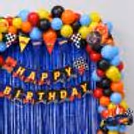 Happy Birthday Bunting And Floating Balloons Along With Kids Hot Wheels Birthday Setup With Racing-Inspired Party Decor.
