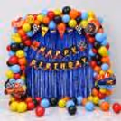 Hot Wheels Birthday Decoration With Multicolour Balloon Arch, Racing Cutouts And Dark Blue Background.