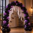 Halloween entrance decor with metallic balloons, hanging bats and web drapes