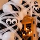 Halloween mummy balloon decoration featuring soft white net fabric, black and white balloons and cute spooky paper eye cutouts.
