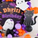 Spooky Halloween backdrop with themed cat and ghost cutouts.
