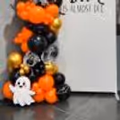 Halloween party decoration with a 7×4 ft customized flex and a 180-balloon arch.