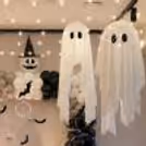 Ghost-themed Halloween decoration with a black, white and pastel grey balloon arch.