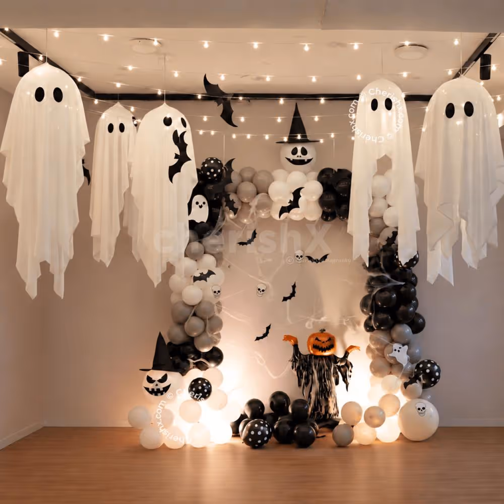 Halloween balloon backdrop featuring bat cutouts, skull accents and a pumpkin ghost foil balloon.