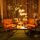 Romantic outdoor candlelight dining setup in a private gazebo surrounded by greenery and ambient lighting.