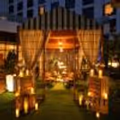 Romantic candlelight gazebo at night featuring rustic wooden décor, warm lights, and an intimate dining atmosphere.