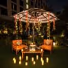 Premium garden date night decor featuring orange lounge chairs, elegant table styling, and candlelight.