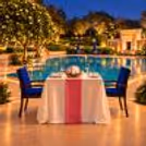 Luxury poolside candlelight dinner for two at The Grand, Vasant Kunj, Delhi, featuring romantic floral décor and an elegant private dining setup.