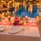 Exclusive poolside candlelight dinner at The Grand, New Delhi, surrounded by landscaped gardens, ambient lighting, and luxury hotel surroundings.