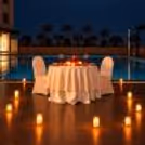 Elegant candlelight dinner table with golden tablecloth, beautiful floral centerpiece, and romantic candles at Hyatt Centric Gurgaon.