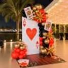 Side view of the casino-themed setup featuring an oversized playing card and golden star balloons.