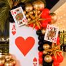 Giant Ace of Hearts playing card backdrop with metallic balloon decorations for a stylish casino party.