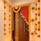 Home decor with traditional Indian door decorations using floral wall hangings for Diwali.