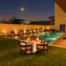 Romantic candlelight dinner setup with red roses, elegant table décor, and warm ambient lighting for couples.